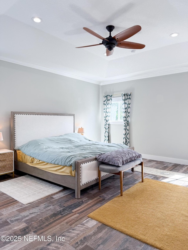 bedroom with wood-type flooring, ceiling fan, crown molding, and a tray ceiling