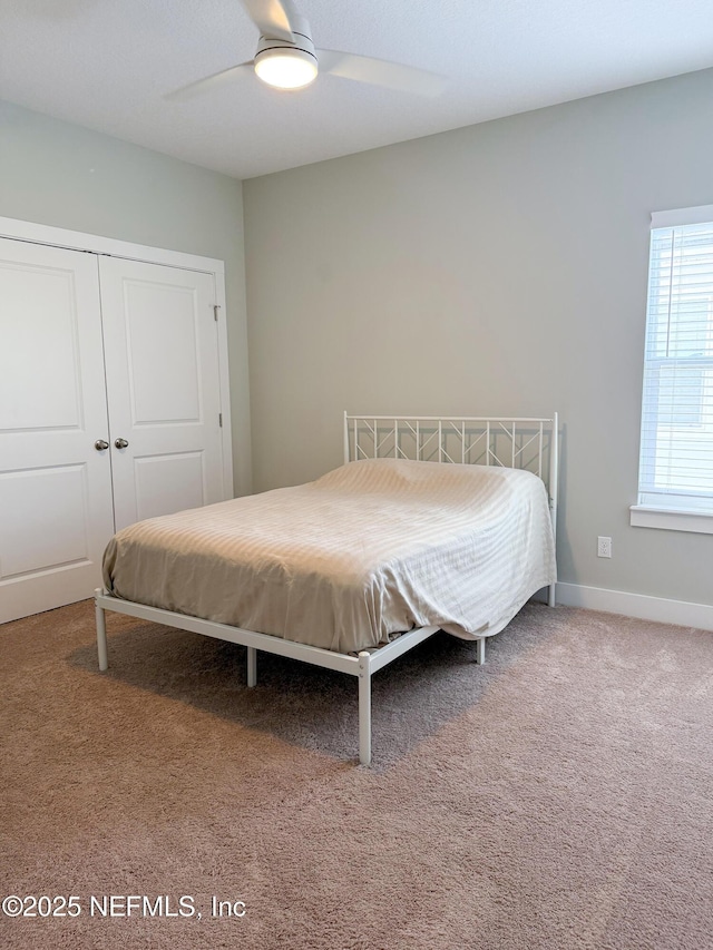 carpeted bedroom featuring ceiling fan and a closet