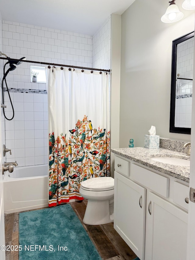 full bathroom with vanity, hardwood / wood-style floors, shower / tub combo, and toilet