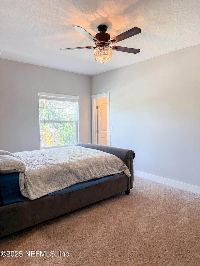 bedroom with ceiling fan, carpet floors, and a textured ceiling