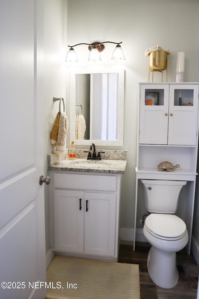 bathroom with vanity, hardwood / wood-style floors, and toilet