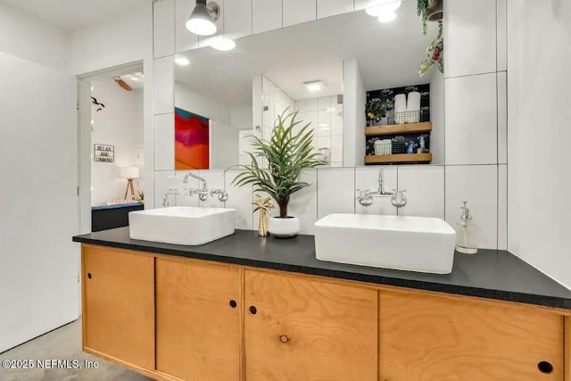 bathroom with tasteful backsplash, vanity, and tile walls