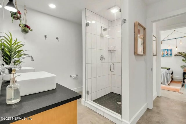 bathroom featuring vanity, a shower with shower door, and concrete floors