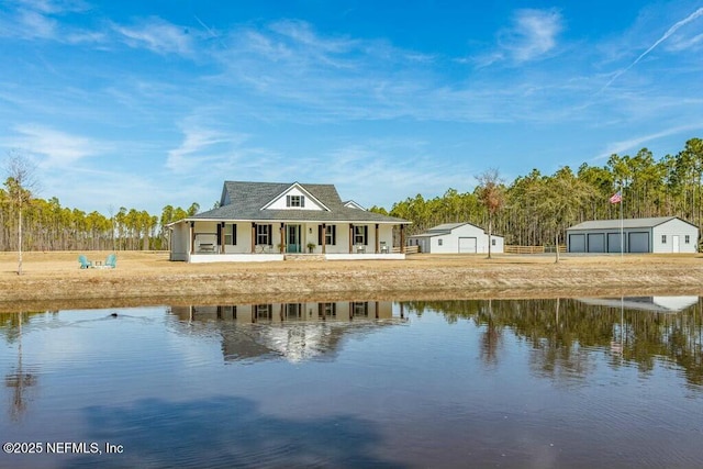 rear view of house with a garage, an outdoor structure, a porch, and a water view