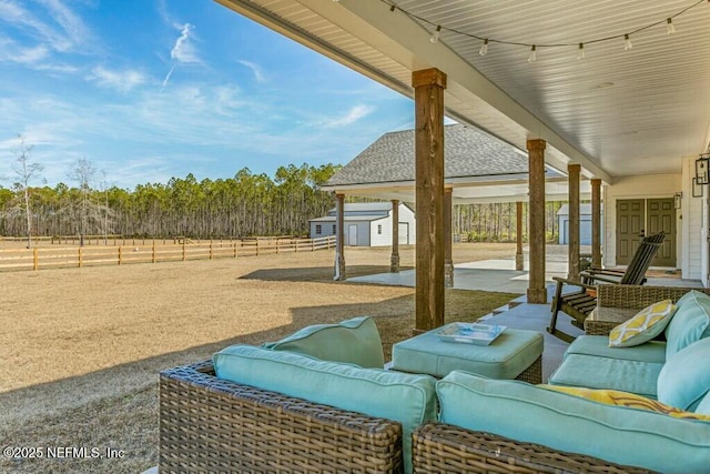 view of patio with a storage unit, outdoor lounge area, and a rural view