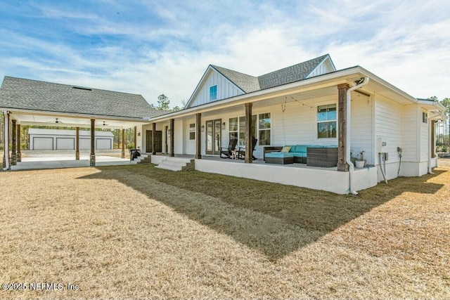 back of property featuring a porch, a garage, and a yard