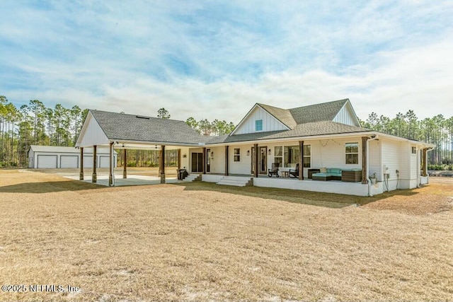 back of property with an outbuilding, a garage, and covered porch