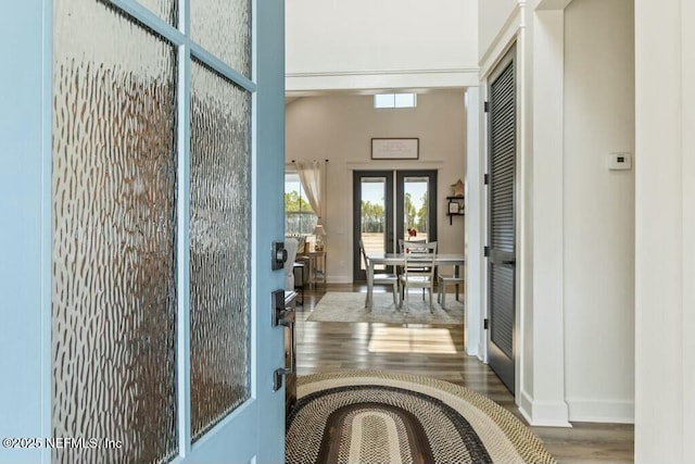 doorway to outside with dark wood-type flooring, french doors, and a high ceiling