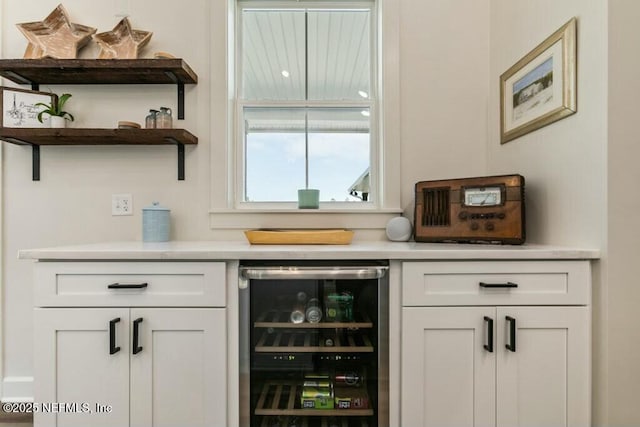 bar featuring wine cooler and white cabinets