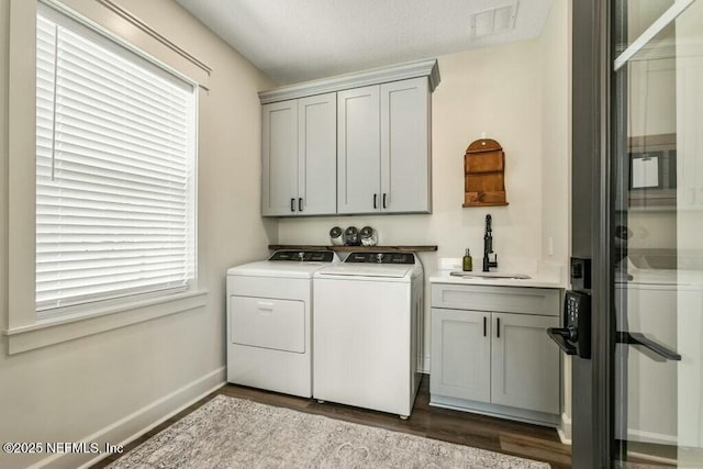 washroom featuring sink, cabinets, a wealth of natural light, wood-type flooring, and washer and dryer