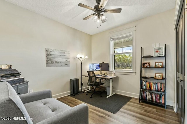 office with hardwood / wood-style floors, a textured ceiling, radiator heating unit, and ceiling fan