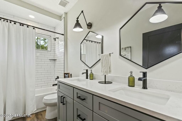 full bathroom featuring vanity, hardwood / wood-style floors, toilet, and shower / bath combo