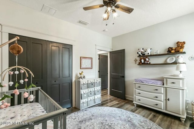 bedroom with ceiling fan, dark wood-type flooring, a textured ceiling, and a closet