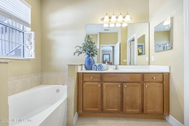 full bathroom with tile patterned floors, a bath, and vanity