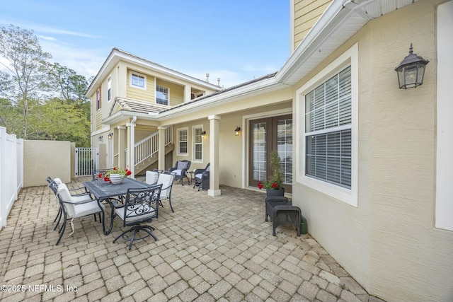 view of patio featuring outdoor dining space, french doors, and fence