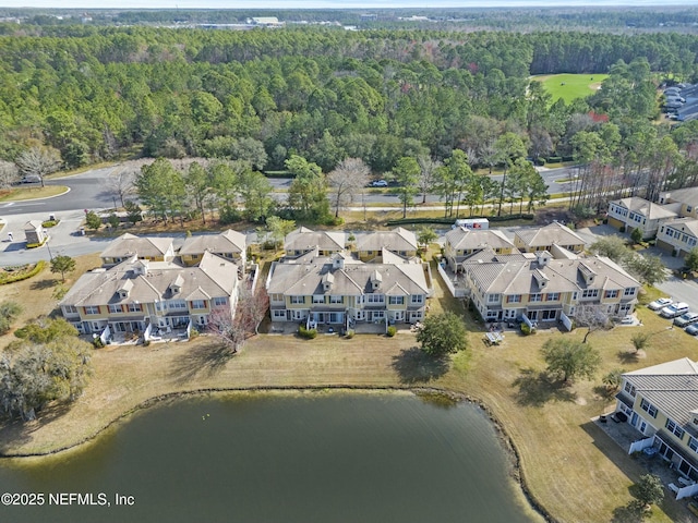 birds eye view of property with a residential view, a water view, and a view of trees