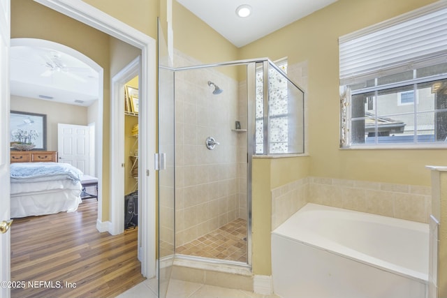 bathroom featuring a shower stall, a ceiling fan, a garden tub, and wood finished floors