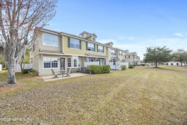 rear view of house with a yard, cooling unit, a patio, and fence