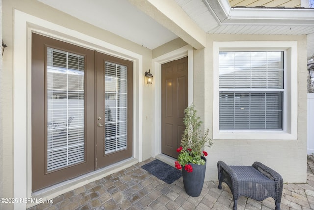 entrance to property featuring french doors and stucco siding