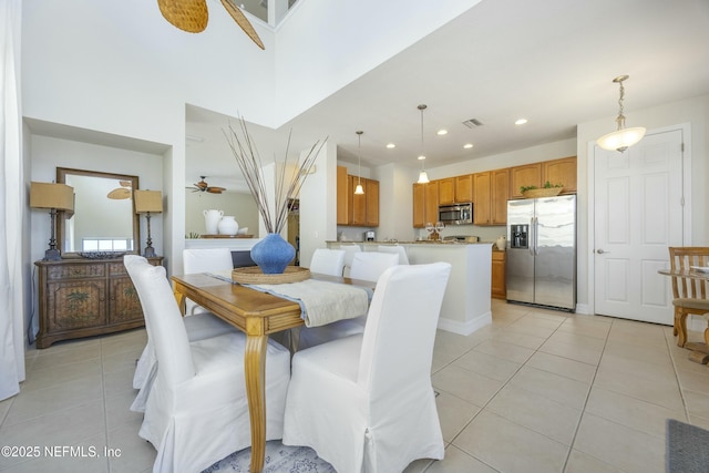 dining space with visible vents, a ceiling fan, recessed lighting, light tile patterned floors, and a towering ceiling