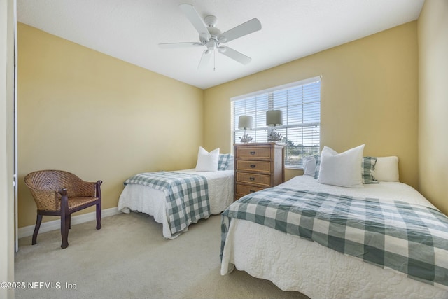 bedroom with light carpet, a ceiling fan, and baseboards