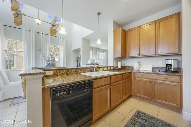 kitchen with a sink, decorative light fixtures, black dishwasher, dark stone counters, and light tile patterned flooring