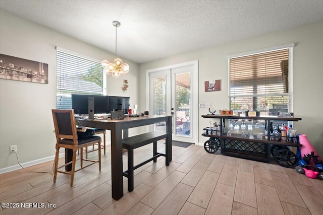 dining room with a textured ceiling, a healthy amount of sunlight, and light wood-type flooring