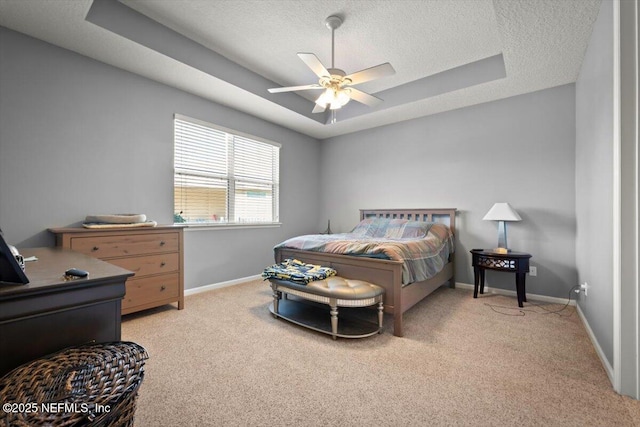 carpeted bedroom with ceiling fan, a raised ceiling, and a textured ceiling