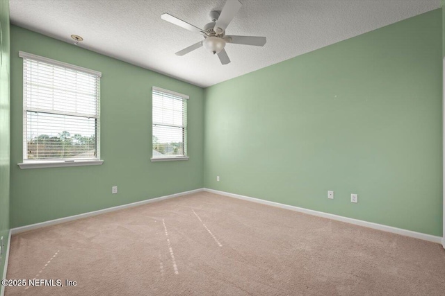 carpeted empty room with ceiling fan and a textured ceiling