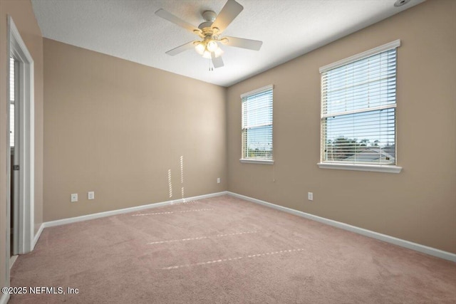 spare room with ceiling fan, light carpet, and a textured ceiling