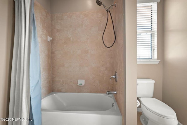 bathroom featuring shower / tub combo and toilet