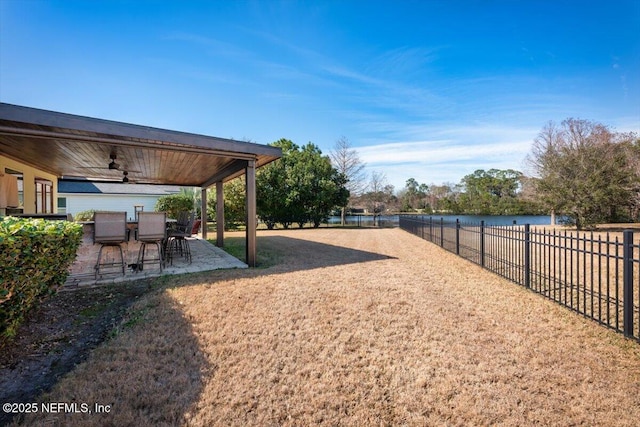 view of yard featuring a patio, a water view, and ceiling fan