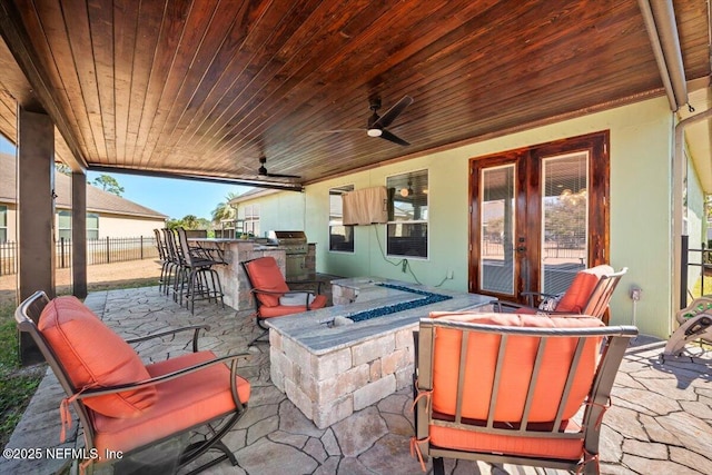 view of patio with a bar, grilling area, area for grilling, and ceiling fan