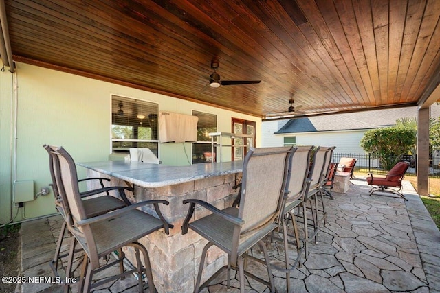 view of patio featuring a bar and ceiling fan