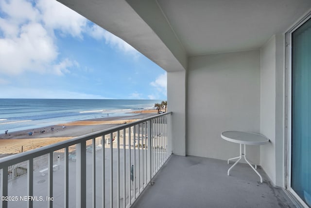 balcony featuring a water view and a beach view