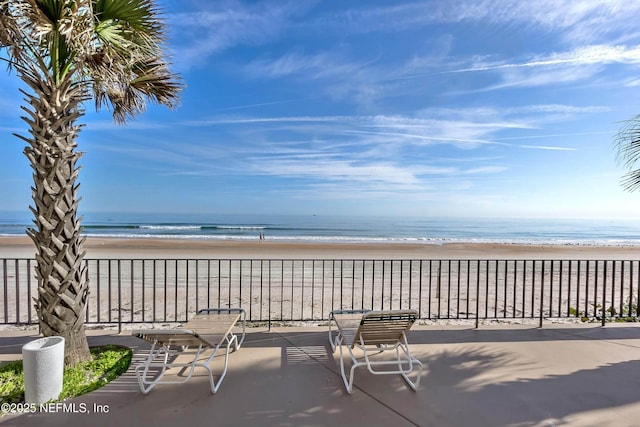 view of patio with a beach view and a water view