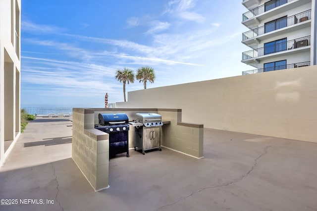 view of patio with a water view and area for grilling