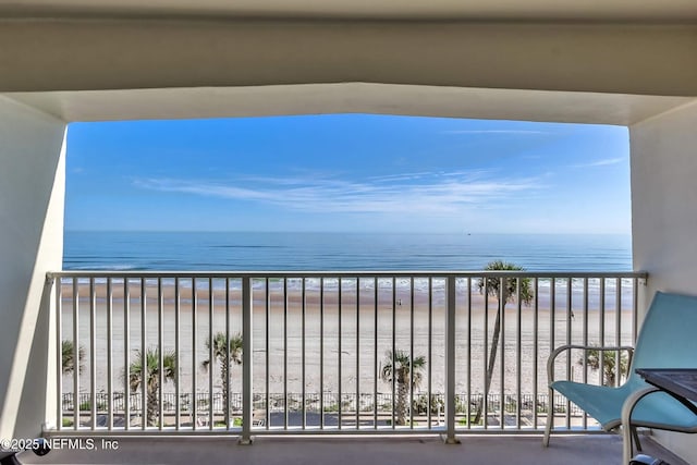 balcony featuring a water view and a view of the beach