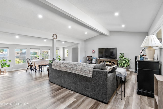 living room with lofted ceiling with beams and light hardwood / wood-style floors