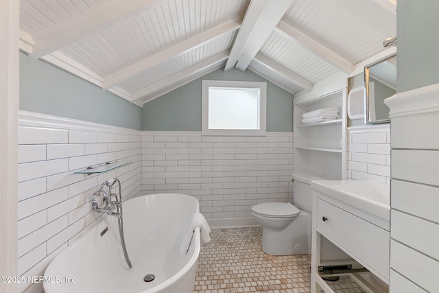 bathroom featuring toilet, lofted ceiling with beams, tile walls, vanity, and a tub