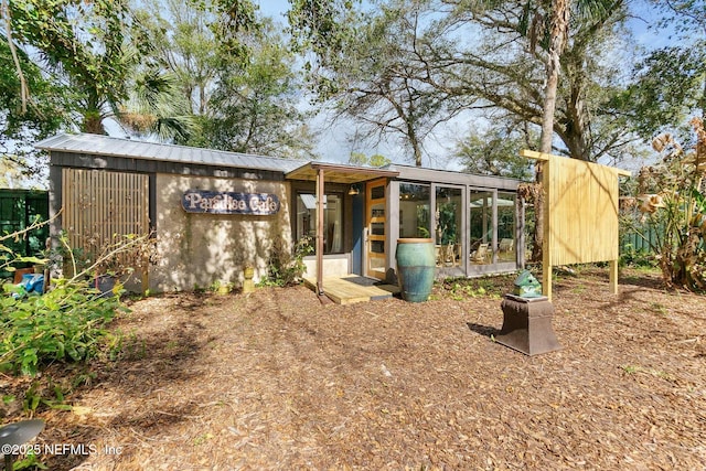 view of outbuilding featuring a sunroom