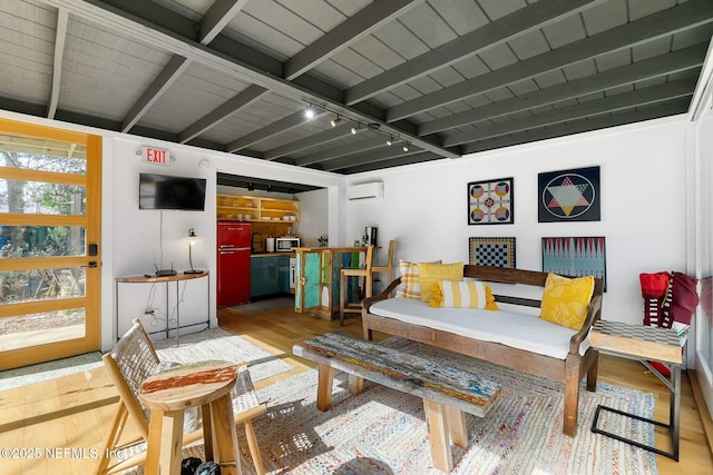 sitting room with rail lighting, wood ceiling, wood-type flooring, a wall mounted AC, and beam ceiling