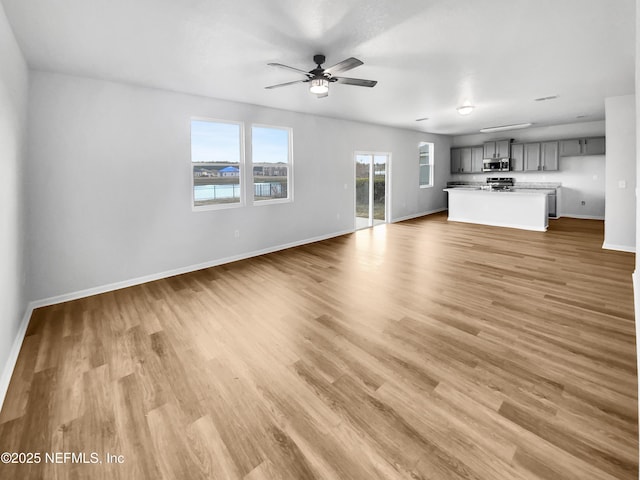 unfurnished living room featuring ceiling fan and light hardwood / wood-style flooring