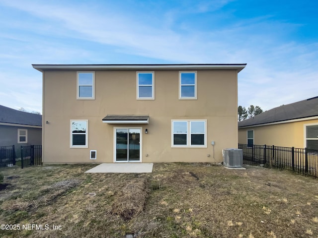 back of house featuring a lawn, central AC unit, and a patio area