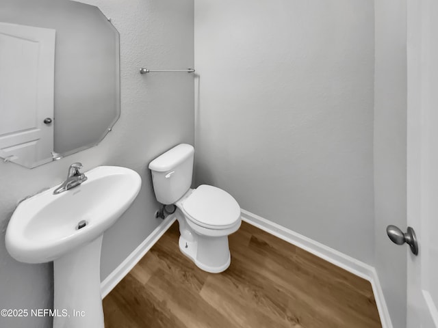 bathroom with hardwood / wood-style flooring and toilet