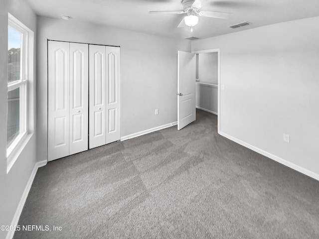 unfurnished bedroom with ceiling fan, a closet, and carpet