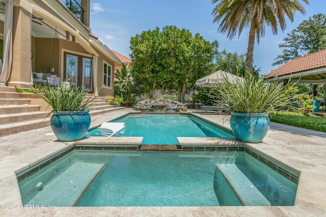 view of swimming pool with an in ground hot tub and a patio