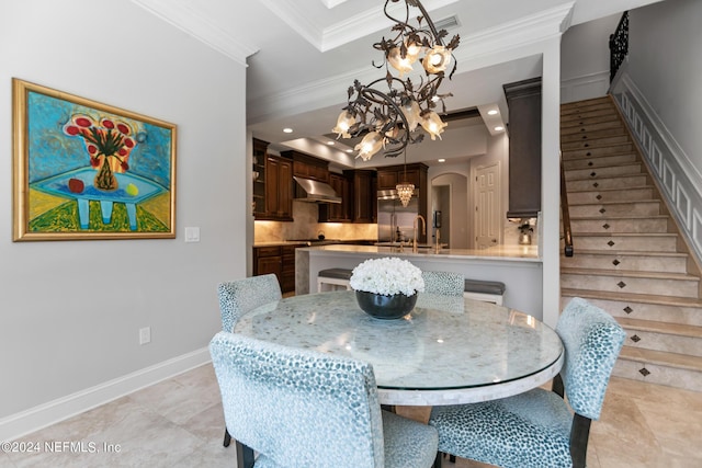 dining room with crown molding, sink, and a notable chandelier