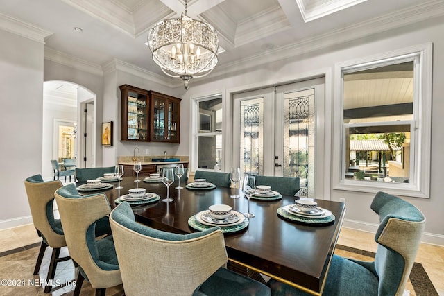 dining area featuring coffered ceiling, a notable chandelier, crown molding, and bar area