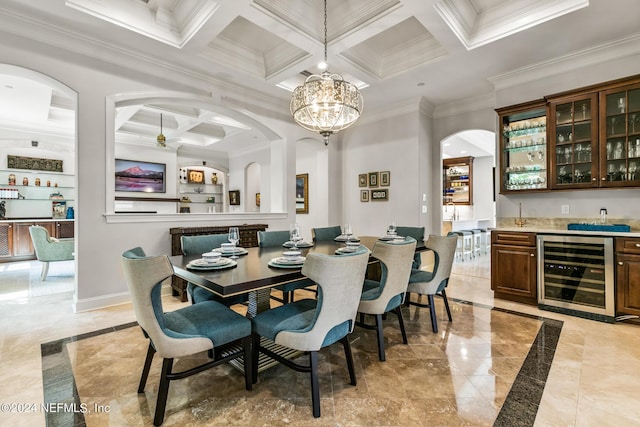 dining space featuring coffered ceiling, bar area, ornamental molding, beamed ceiling, and beverage cooler